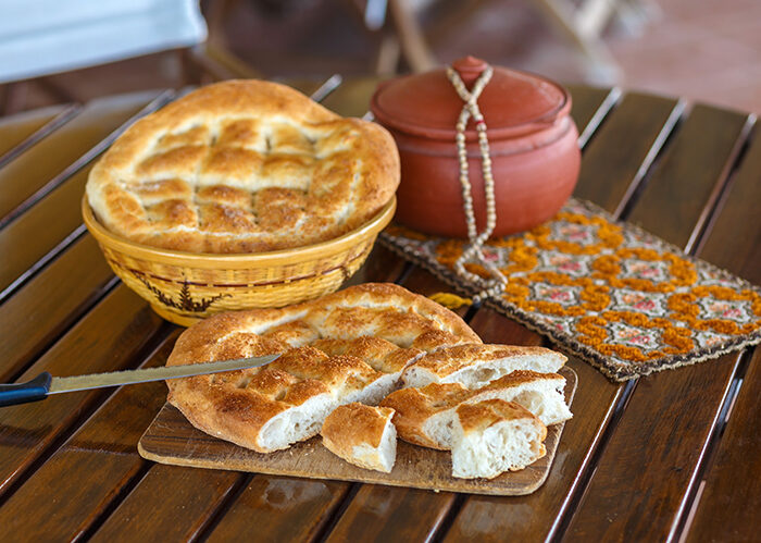 Ramadan pide cut and outdoor served with rasary, breadbasket  and pottery. photo with shallow depth of field